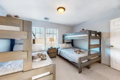 a bedroom with two bunk beds and a window at Modern Mountain in Tannersville