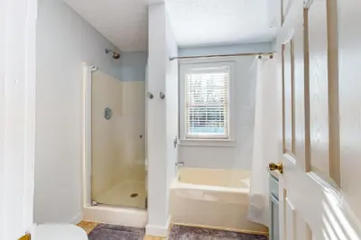 a white bathroom with a shower and a tub at Modern Mountain in Tannersville