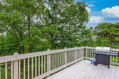 a grill on a wooden deck with a fence at Modern Mountain in Tannersville
