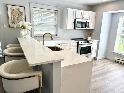 a kitchen with white cabinets and a white counter top at Modern Mountain in Tannersville