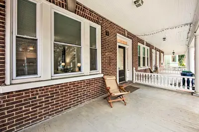 a rocking chair on a porch of a brick building at Lancaster Unit with Expansive Covered Porch! in Lancaster