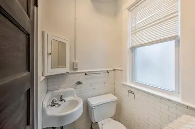 a bathroom with a sink and a toilet and a window at Roomy Lancaster Home Walk to Dtwn and Hospital in Lancaster