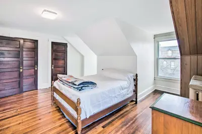 a bedroom with a bed and two wooden doors at Roomy Lancaster Home Walk to Dtwn and Hospital in Lancaster