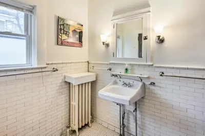 a white bathroom with a sink and a mirror at Roomy Lancaster Home Walk to Dtwn and Hospital in Lancaster