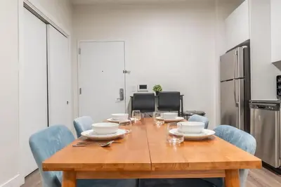 a dining room table with blue chairs and a kitchen at Blue Breakaway with Free Parking and Sleeps 9, Book 7 days, Get 20 Percent OFF in East Orange