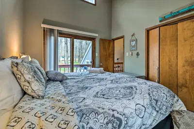 a bedroom with a bed with a blue and white comforter at Walk to Locust Lake Poconos Vacation Home! in Pocono Lake
