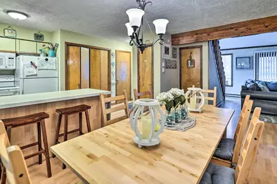 a kitchen and dining room with a wooden table at Walk to Locust Lake Poconos Vacation Home! in Pocono Lake