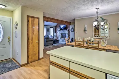 a kitchen and living room with a table and chairs at Walk to Locust Lake Poconos Vacation Home! in Pocono Lake