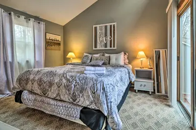 a bedroom with a large bed and two lamps at Walk to Locust Lake Poconos Vacation Home! in Pocono Lake