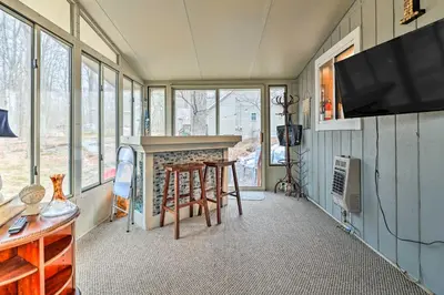 a living room with a fireplace and a tv at Walk to Locust Lake Poconos Vacation Home! in Pocono Lake