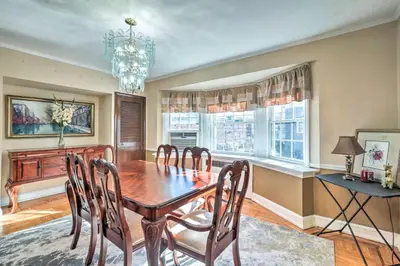 a dining room with a table and chairs and a chandelier at Yeadon Townhome with Porch, 7 Mi to Center City in Drexel Hill