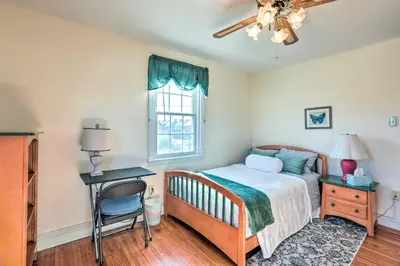 a bedroom with a bed and a desk and a window at Yeadon Townhome with Porch, 7 Mi to Center City in Drexel Hill