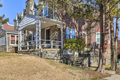 a stone house with an awning on the front of it at Yeadon Townhome with Porch, 7 Mi to Center City in Drexel Hill