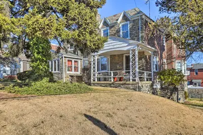 a house with a large yard in front of it at Yeadon Townhome with Porch, 7 Mi to Center City in Drexel Hill