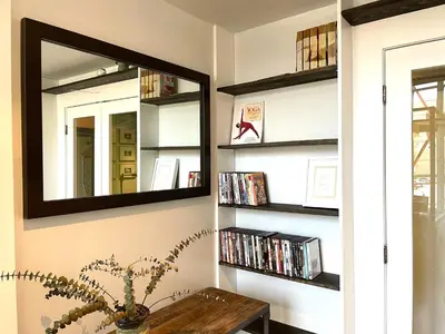 a mirror on a wall with a table and dvds at Duplex Suite in Art Tower in Philadelphia