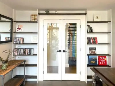 a room with a door and shelves with books at Duplex Suite in Art Tower in Philadelphia