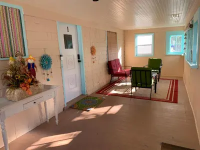 a room with chairs and a table and a door at Newly renovated 4 bedroom apartment near downtown. in Montclair