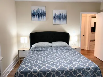 a bedroom with a bed and two lamps at Newly renovated 4 bedroom apartment near downtown. in Montclair