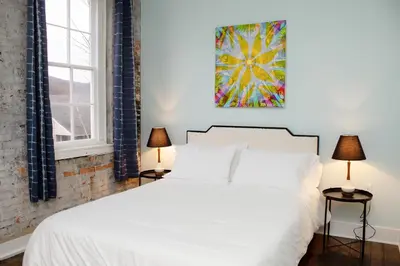 a bedroom with a white bed and two lamps at Bischoff Inn - Former 1870 Furniture Factory Now 5 Room Boutique Hotel in Tamaqua