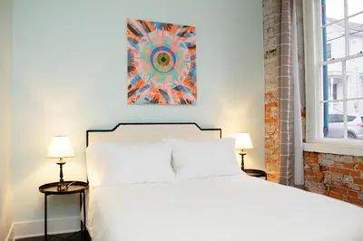a bedroom with a white bed and two lamps at Bischoff Inn - Former 1870 Furniture Factory Now 5 Room Boutique Hotel in Tamaqua