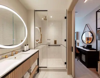 a bathroom with a sink and a shower and a mirror at Tempo By Hilton New York Times Square in New York