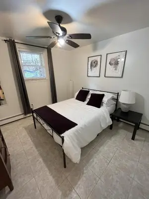 a bedroom with a bed and a ceiling fan at Two Bedroom Private Apt near NYC in West New York