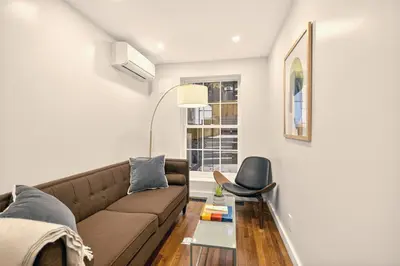 a living room with a couch and a chair at Outsite Chelsea in New York