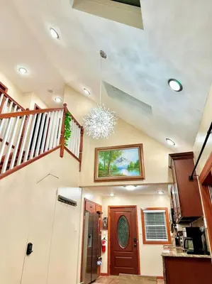 a living room with a staircase and a chandelier at Chic Chalet River Views & Access in Montague