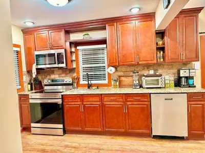 a large kitchen with wooden cabinets and appliances at Chic Chalet River Views & Access in Montague