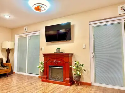 a living room with a fireplace and a flat screen tv at Chic Chalet River Views & Access in Montague