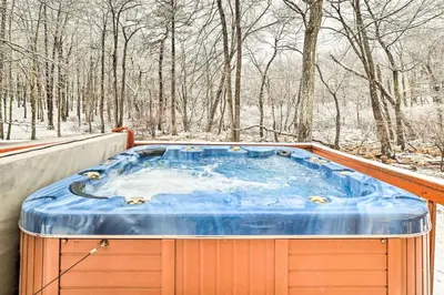 a jacuzzi tub on a deck in the snow at Hot Tub and Deck Pet-Friendly Poconos Getaway! in Bushkill