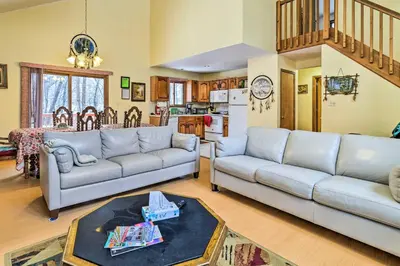 a living room with two couches and a kitchen at Hot Tub and Deck Pet-Friendly Poconos Getaway! in Bushkill