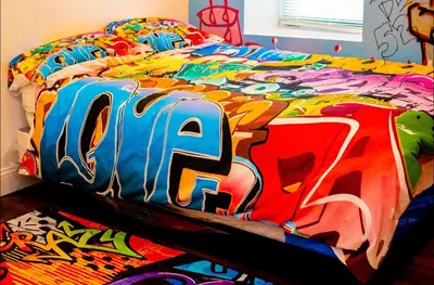 a bed with a colorful comforter with the wordio at Art Deco Graffiti Suite in Philadelphia