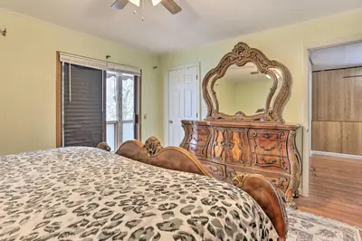 a bedroom with a large wooden bed and a large mirror at Large Greeley House with 2 Game Rooms and Yard! in Lackawaxen