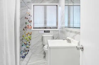 a bathroom with a toilet and a sink and a window at Large Greeley House with 2 Game Rooms and Yard! in Lackawaxen