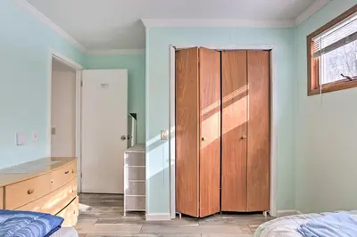 a bedroom with a wooden closet and a bed at Large Greeley House with 2 Game Rooms and Yard! in Lackawaxen