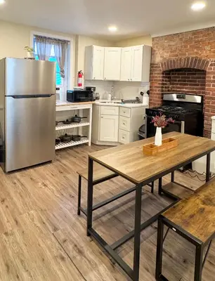 a kitchen with a stainless steel refrigerator and a table at Classical Isbills Row House close to NYC in Bayonne