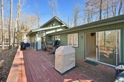 a green house with a large patio on a deck at Pocono Pines, Lake Naomi 4 bedrooms, 2 full bath in Pocono Pines