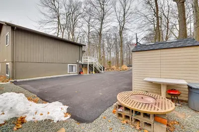 a building with a bench next to a parking lot at 8 Mi to Tobyhanna State Park Poconos Home! in Mushroom Farms