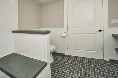 a white bathroom with a toilet and a door at Craftsman Hideaway at the 1841 Farmhouse in Chester