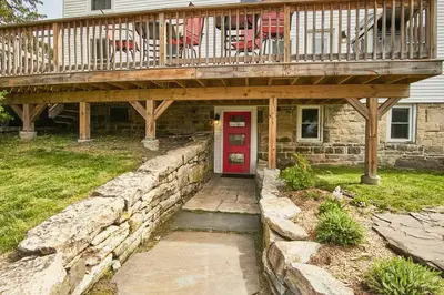 a deck with a red door on a house at Craftsman Hideaway at the 1841 Farmhouse in Chester
