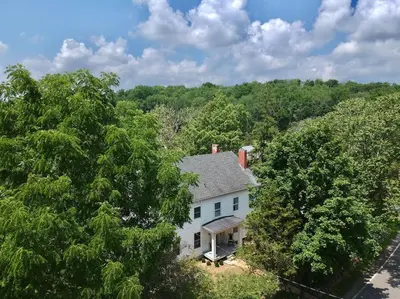 an aerial view of a white house in the woods at Craftsman Hideaway at the 1841 Farmhouse in Chester