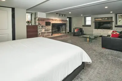 a bedroom with a white bed and a fireplace at Craftsman Hideaway at the 1841 Farmhouse in Chester