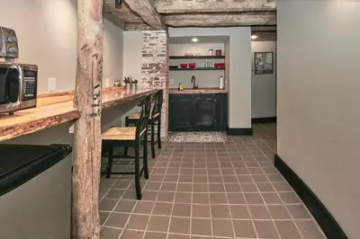 a kitchen with a bar with chairs and a counter at Craftsman Hideaway at the 1841 Farmhouse in Chester