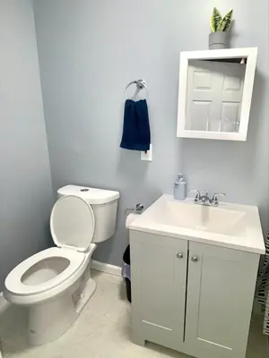 a bathroom with a white toilet and a sink at Cozy Apartments close to New York City in North Bergen