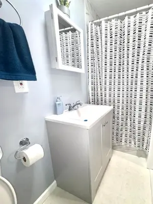 a white bathroom with a sink and a toilet at Cozy Apartments close to New York City in North Bergen