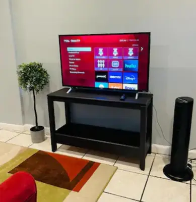 a flat screen tv sitting on a stand in a living room at Cozy Apartments close to New York City in North Bergen