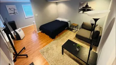 a bedroom with a bed and a couch and a table at Cozy Apartments close to New York City in North Bergen