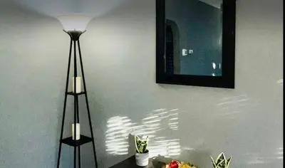 a lamp sitting next to a wall with a mirror at Cozy Apartments close to New York City in North Bergen