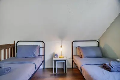 two beds in a room with a table and a lamp at Camp Cedar:7 miles to Camelback, 5 to Kalahari! in Long Pond